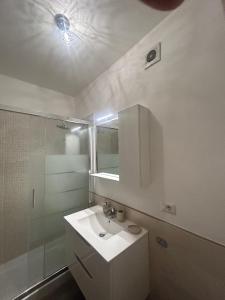 a white bathroom with a sink and a shower at RED SKY APARTMENT - PORTA DI ROMA in Rome