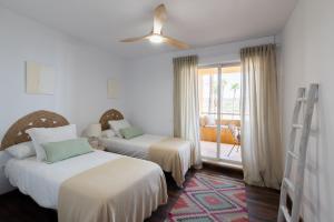 a hotel room with two beds and a balcony at Puerto Sotogrande con vistas al mar in Sotogrande