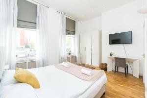 una camera bianca con letto e scrivania di Spacious 2 bedroom / Gloucester Road / Kensington a Londra