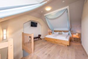 a bedroom with a bed with a mosquito net at Heuboden Hotel Landhaus Blum in Umkirch