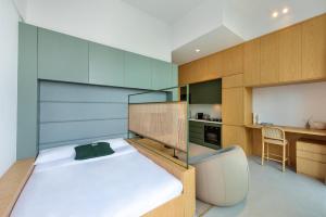 a small bedroom with a bed and a kitchen at The Muse in Dubai