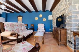 sala de estar con paredes azules y chimenea de piedra. en Casa Dieste Apartamentos Turísticos en Boltaña, en Boltaña