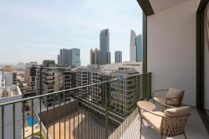 a balcony with two chairs and a view of a city at The Muse in Dubai