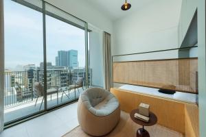 un soggiorno con sedia e una grande finestra di The Muse a Dubai