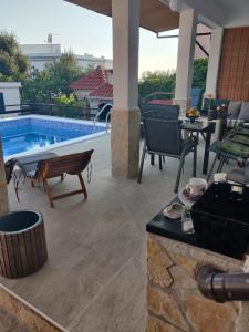 a patio with a pool and a table and chairs at Deni in Sevid