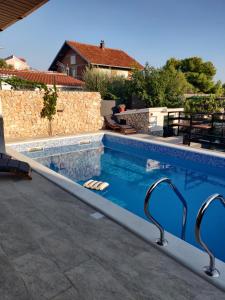 a swimming pool in a house with a stone wall at Deni in Sevid