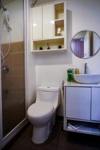 ein Badezimmer mit einem WC, einem Waschbecken und einem Spiegel in der Unterkunft Modern Designed Studio Condo Near Ayala Centrio in Cagayan de Oro