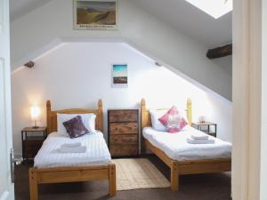 two twin beds in a room with stairs at Pass the Keys Heart of Llandovery Large 4BR Apartment For 9 in Llandovery
