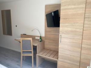 Zimmer mit einem Schreibtisch mit Stuhl und einem TV in der Unterkunft Hotel Gloria in Alsdorf