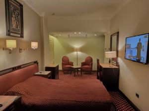 a hotel room with a bed and a flat screen tv at Queen Hotel Fayoum in Fayoum