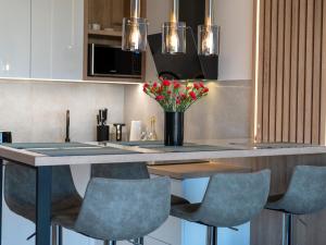 a kitchen with a table with chairs and a vase of flowers at Duplex holiday apartment Rewal in Rewal