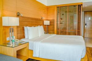 a bedroom with a large white bed and a table at Courtyard by Marriott Gurugram Downtown in Gurgaon