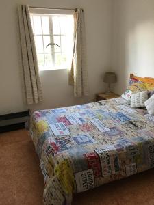 a bedroom with a bed with a quilt on it at L'Ardenne Bleue Appartement in Rivière Noire