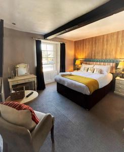 a large bedroom with a large bed and a chair at The Bay Horse, Masham in Masham