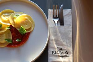 een bord eten op een tafel met een vork en mes bij Ca' Bianca Tuscany Relais in Siena