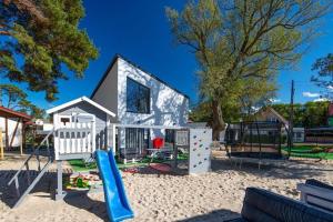 a small house with a playground in the sand at Cottage near the beach for 3 people in Pustkowo in Pustkowo