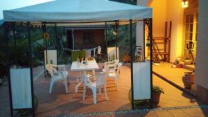 cenador con mesa y sillas en el patio en Room in Villa - Hillside room with garden and sea view, en San Salvatore
