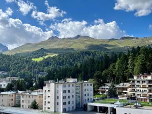 uma cidade com edifícios e uma montanha ao fundo em Hotel Stille em St. Moritz