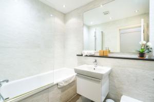 La salle de bains est pourvue d'un lavabo, d'une baignoire et de toilettes. dans l'établissement Spacious 2 bedroom / Earls Court / Kensington, à Londres
