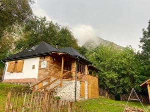 une maison en bois avec un toit noir dans l'établissement BATS CAVE HUT - Transylvania - Hot-Tub - Sauna, à Sub Piatra