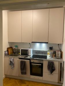 cocina con armarios blancos y microondas en Shared apartment close to the city center en Estocolmo