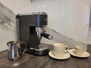 a coffee maker with two coffee cups on a counter at Comfy apartment near the sea in G ski in Gąski