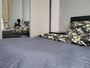 a bedroom with a large bed with a gray blanket at Comfy apartment near the sea in G ski in Gąski