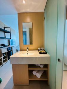 a bathroom with a sink and a mirror at The Arena Cam Ranh Beach Front in Cam Ranh