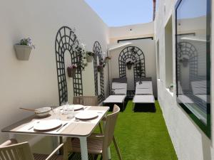 a table and chairs on a balcony with green grass at Bungalow Paseo del Mar- PLAYA ROCA Residence sea front access - Free AC - Wifi in Costa Teguise