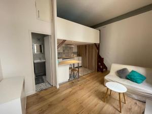 een kleine woonkamer met een bank en een keuken bij Studio Mezzanine N Dame in Versailles