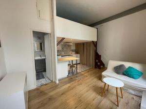 een woonkamer met een witte bank en een keuken bij Studio Mezzanine N Dame in Versailles