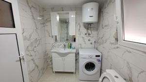 a white bathroom with a washing machine and a sink at Montenegro apartments Phoenix in Bar, Susanj