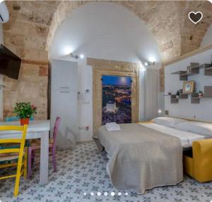 a bedroom with a bed and a table and chairs at una volta al centro via roccamara in Nardò +25 photos