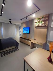 a living room with a bed and a flat screen tv at Canto do Bosque Home office in Campinas