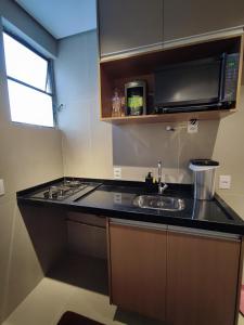 a kitchen with a sink and a microwave at Canto do Bosque Home office in Campinas