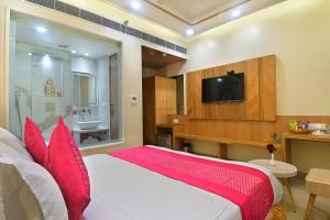 a bedroom with a large bed with red pillows at Hotel Gold Palace - 03 Mins Walk From New Delhi Railway Station in New Delhi