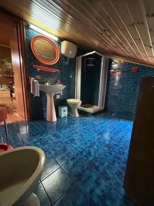 a bathroom with a blue tiled floor and a sink at In mezzo al bosco in Salerni