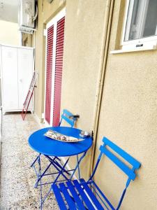 a blue table and two chairs next to a building at Dani's boho home in Missolonghi