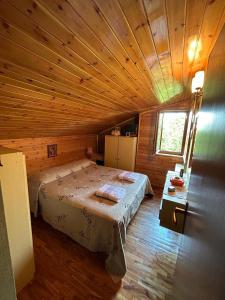 1 dormitorio con 1 cama en una cabaña de madera en In mezzo al bosco, en Salerni