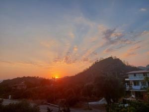 a sunset over a mountain with the sun setting at Zima Art Studio in Marmaris