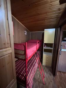 a red bunk bed in a small room with a refrigerator at In mezzo al bosco in Salerni