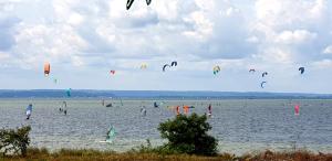 a group of people flying kites in the water at Hotel Autokar Kamper 2 pietrowy, kuchnia, wc, kapsuly sypialne in Jastarnia