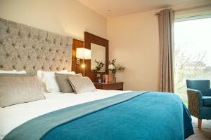 um quarto com uma cama grande e uma cadeira azul em The Wyatt Hotel em Westport