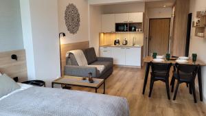 a living room with a bed and a couch and a table at Apartament Laguna Beskidów 57 Góry i Jezioro - Dream Apart in Zarzecze