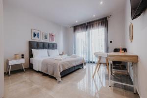 een slaapkamer met een groot bed, een bureau en een tafel bij Pearl Apartel in Volos