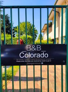 a sign on a fence in front of a building at B&B Colorado in Bergamo