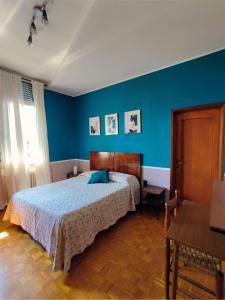 a bedroom with a bed and a blue wall at B&B Colorado in Bergamo