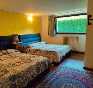 a hotel room with two beds and a window at B&B Colorado in Bergamo