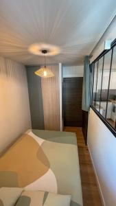 1 dormitorio con 1 cama y una luz en el techo en T2 30m2 proche plage, rénové et équipé, en Bormes-les-Mimosas