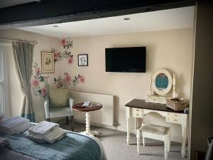 a bedroom with a bed and a desk and a television at The Bay Horse, Masham in Masham